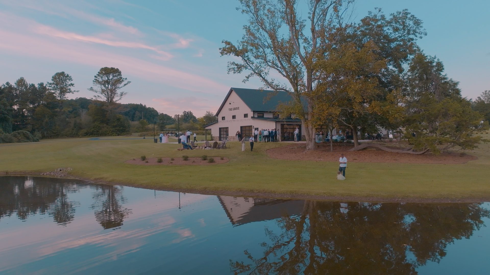 Aerial drone view of The Grove at Defoor Farms wedding venue in Temple, Georgia, beside its pond at sunset