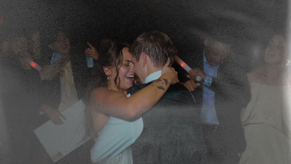 Melyiah and Austin embracing on a hazy, crowded dance floor at their reception